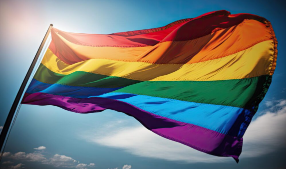 Bandeira do arco-íris tremulando ao vento sob o céu azul